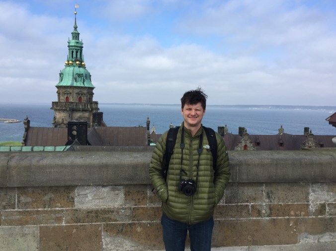 a man stands on front of a view of the Oresund strait