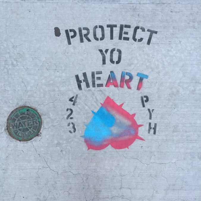 sidewalk graffiti that says "Protect Yo Heart"